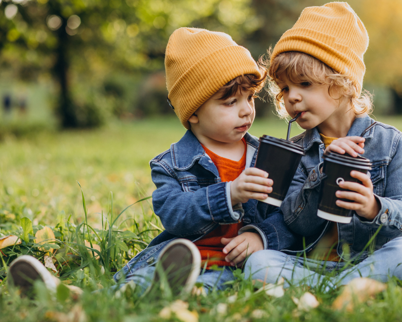Два маленьких  брата сидят на траве