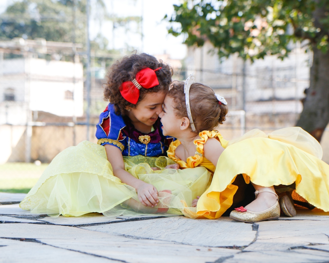 Две маленькие сестры играют под деревом