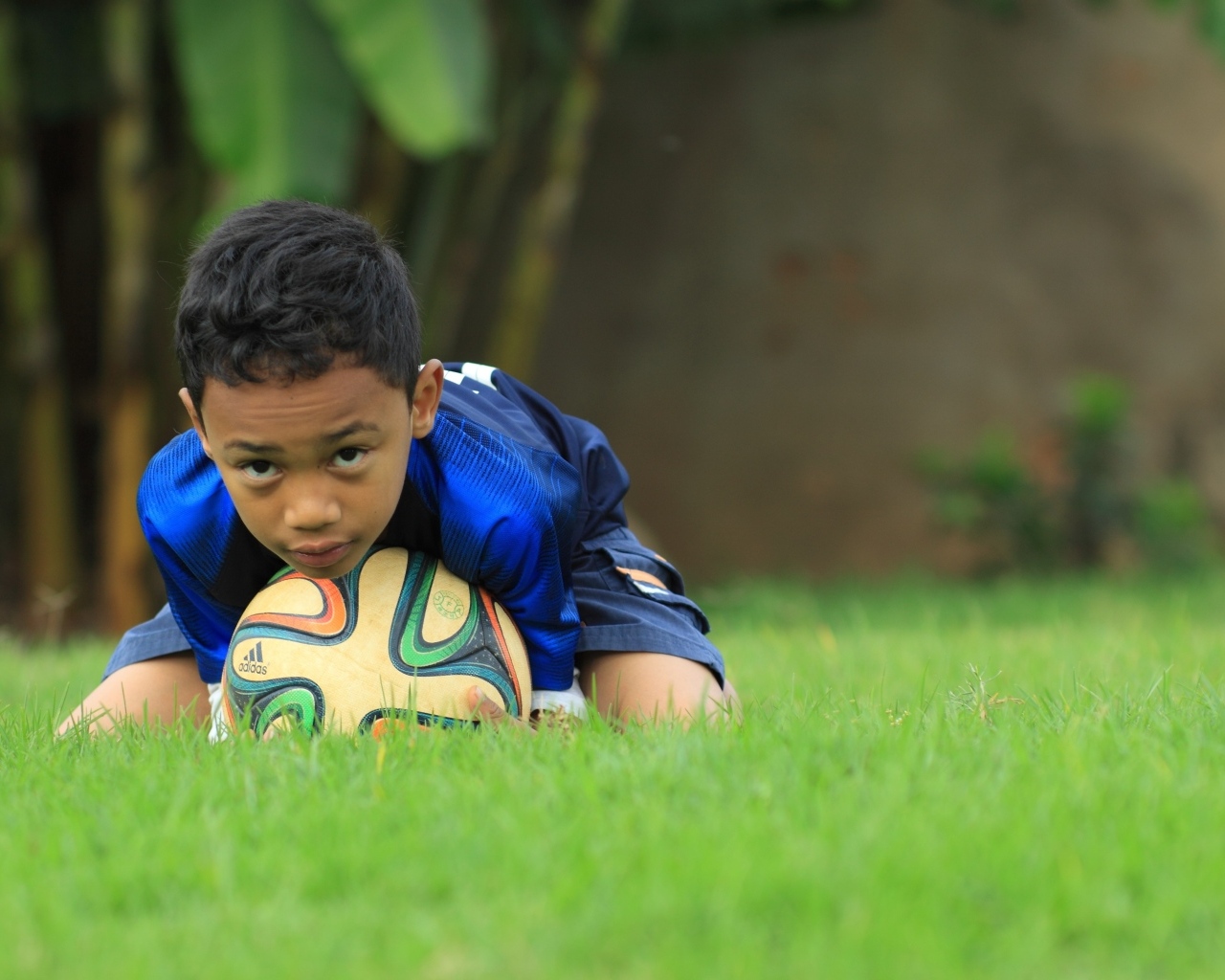 Мальчик юный футболист с мячом на поле