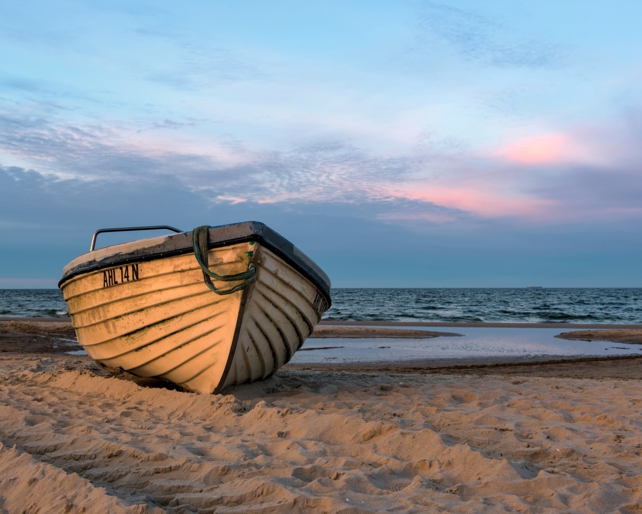 Лодка стоит на песке у моря летом