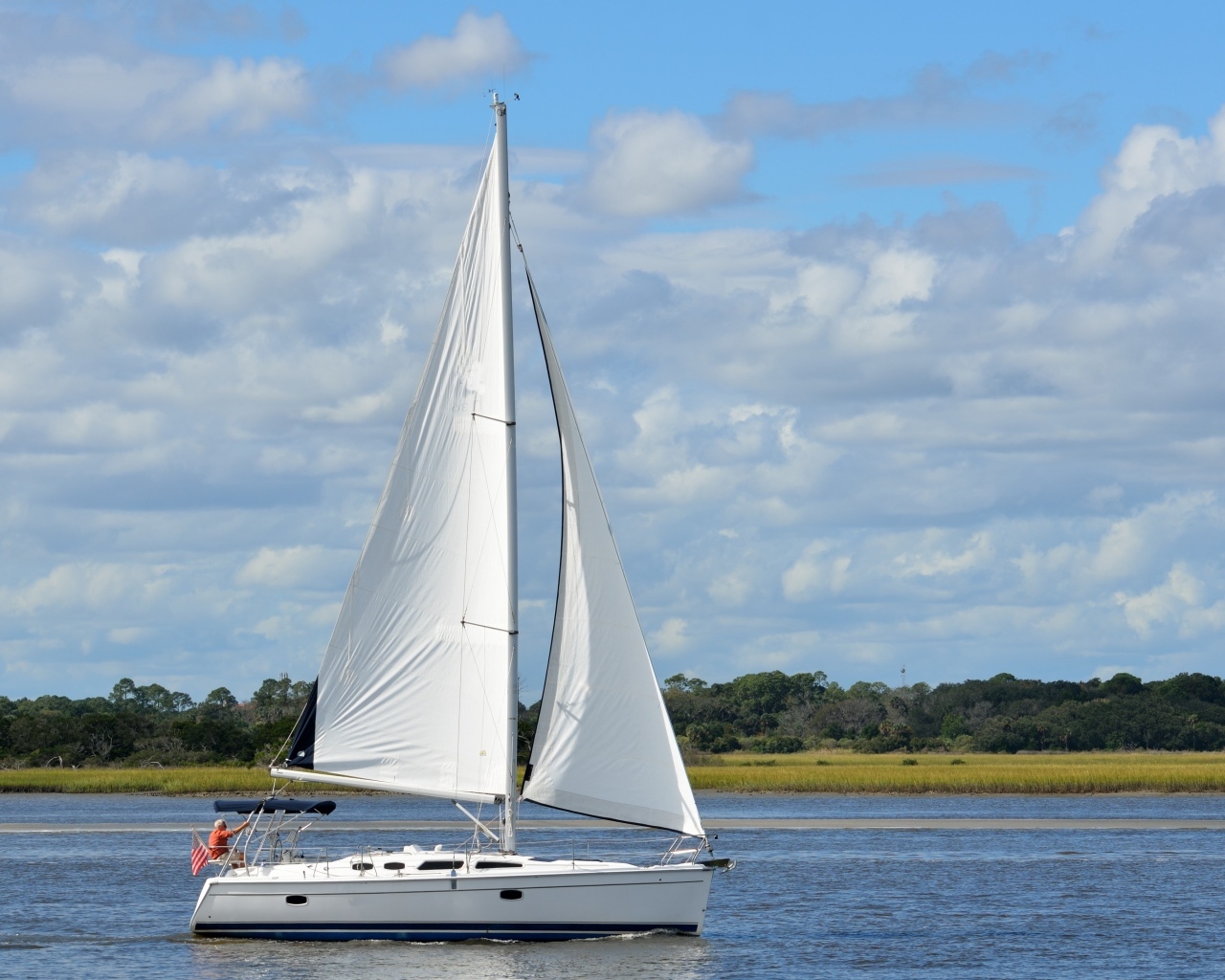Яхта с белыми парусами на реке