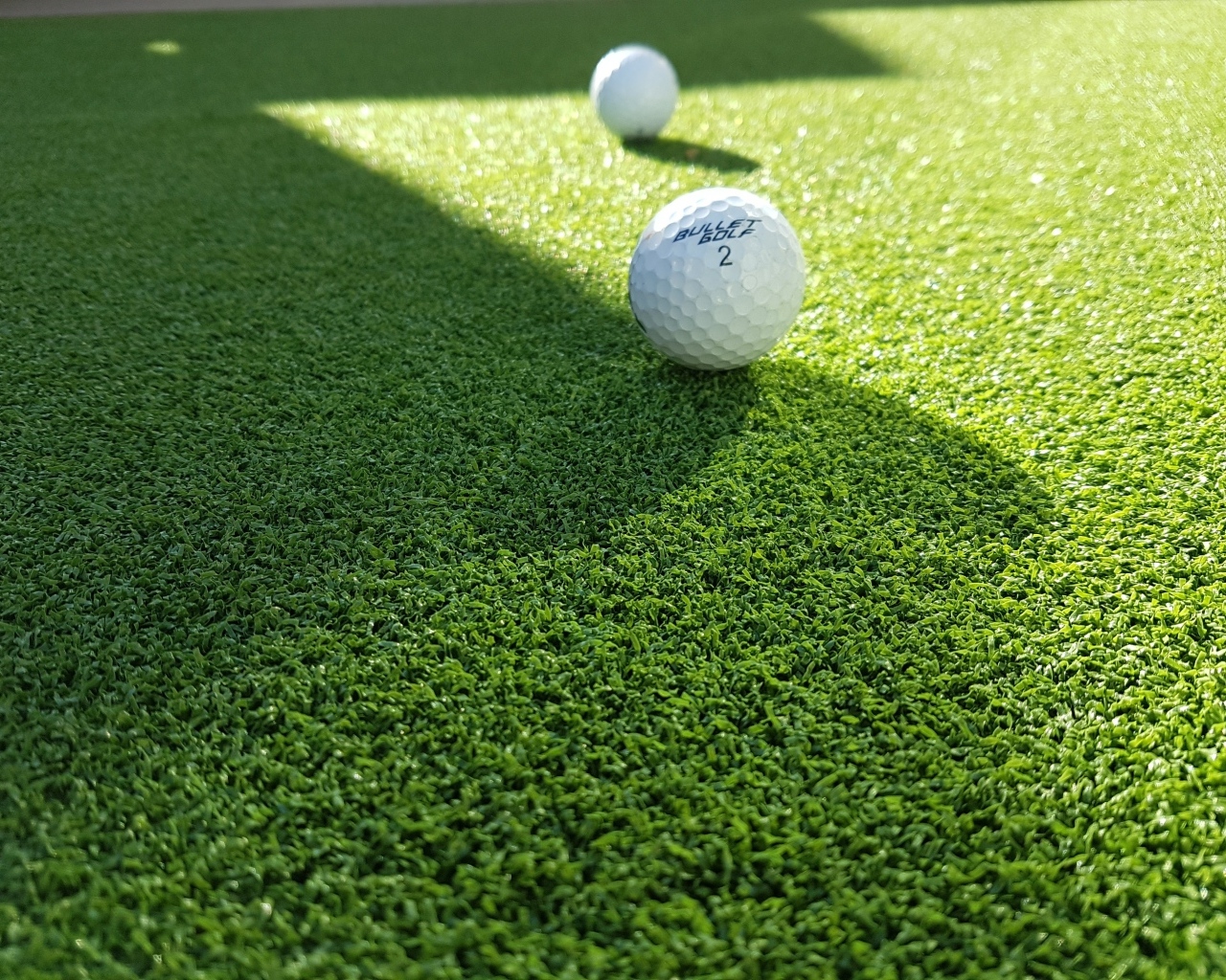 Мячи для гольфа на зеленой траве