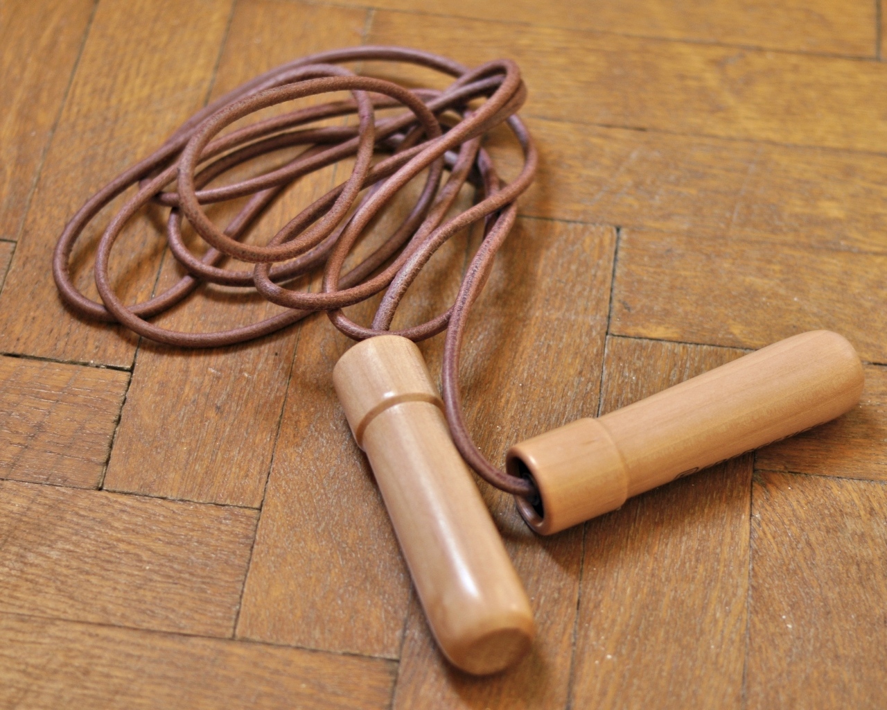 Скакалка лежит на деревянном полу