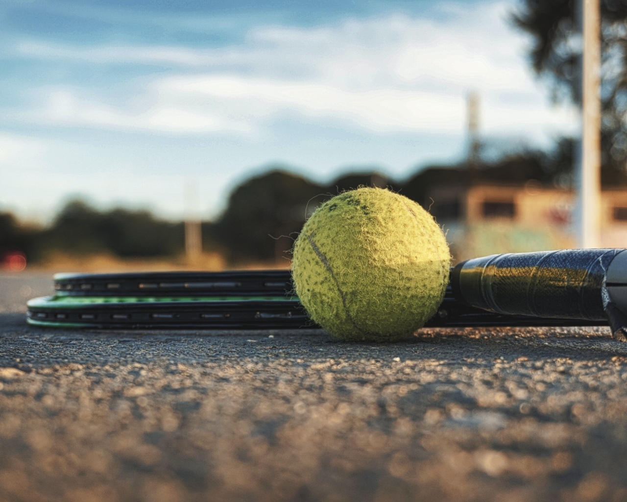 Желтый мяч и две ракетки для игры в теннис