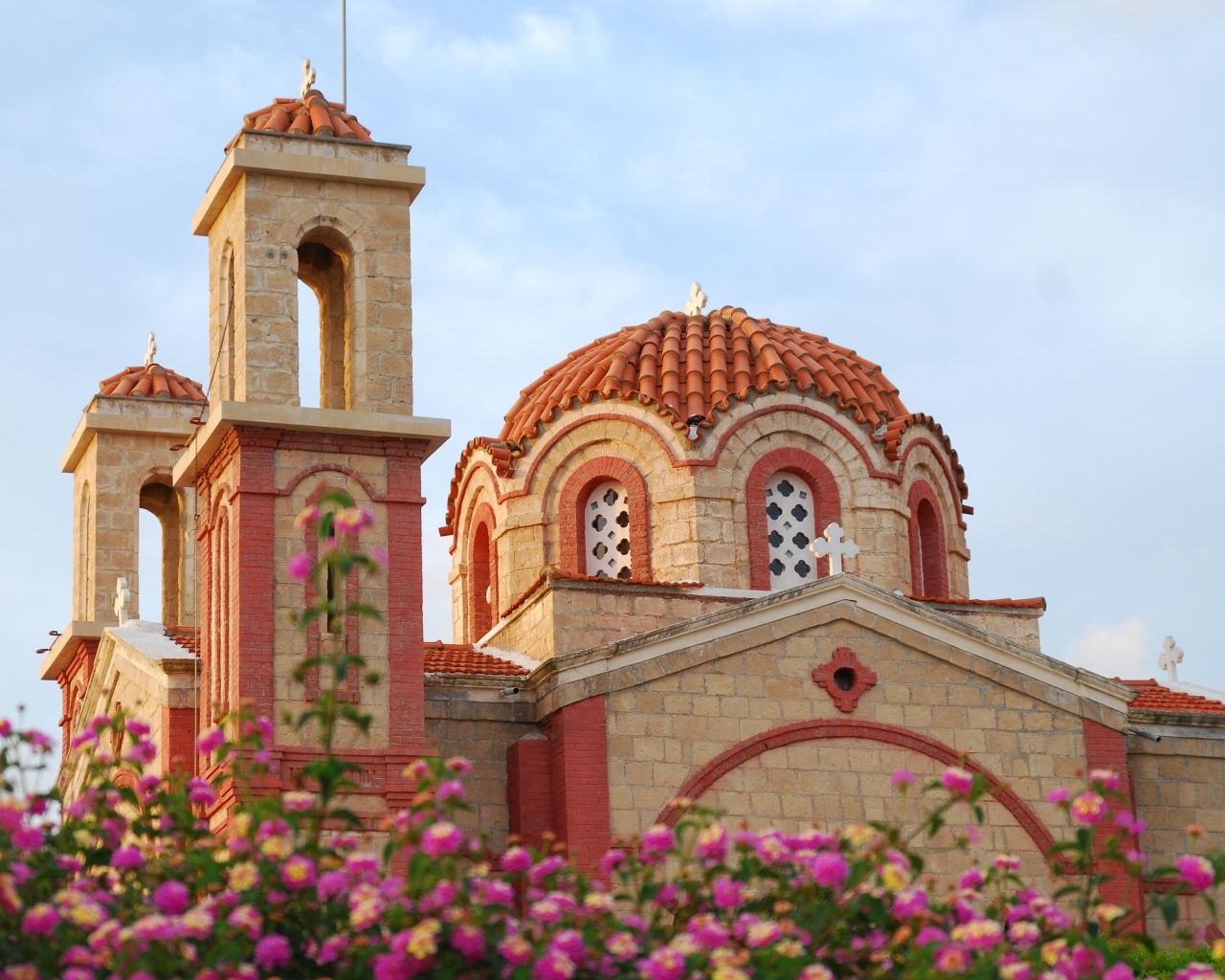 Красивое здание церкви у клумбы с цветами