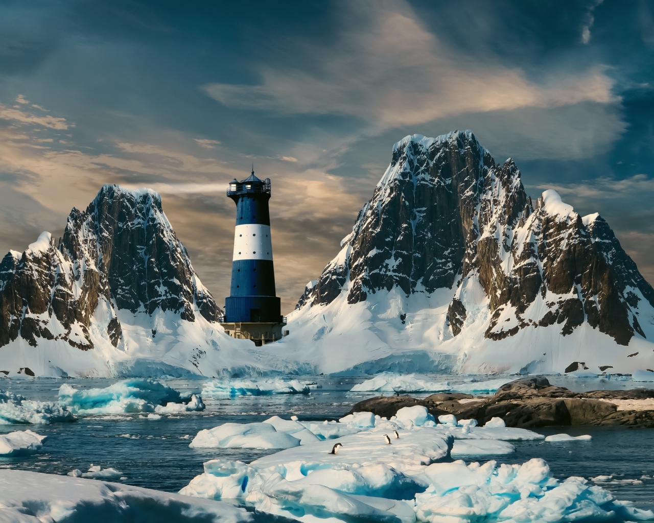 Большие льдины в воде у маяка в горах, Антарктида