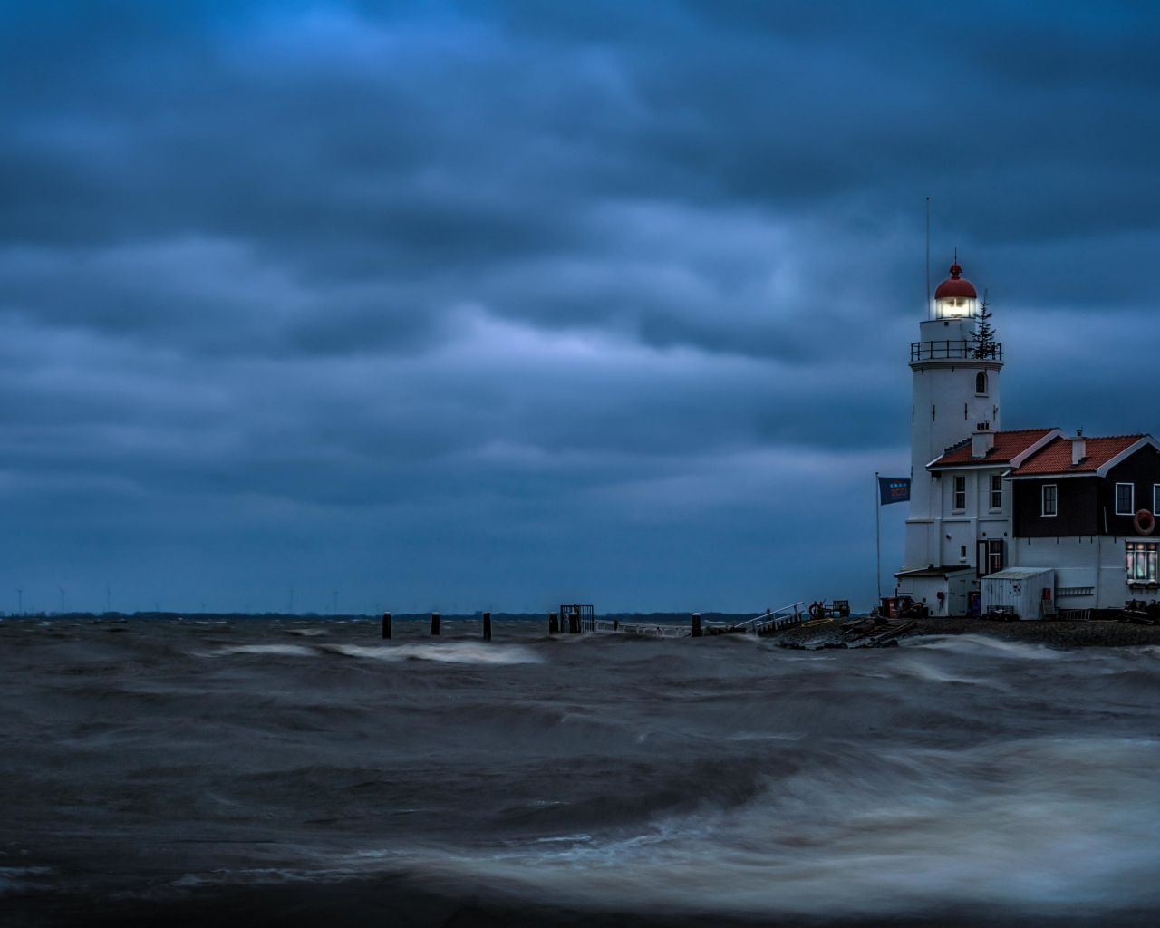 Маяк на морском побережье в сумерках, Голландия. Нидерланды