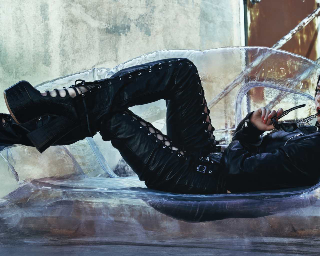 Актриса Аня Тейлор-Джой в черном костюме лежит на диване