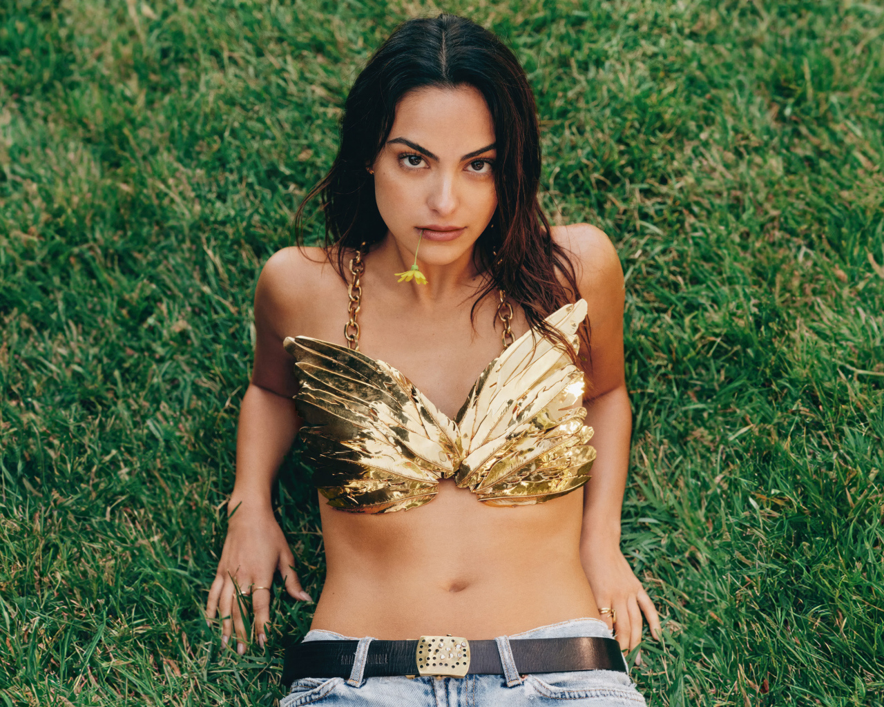 Актриса Камила Мендес лежит на зеленой траве