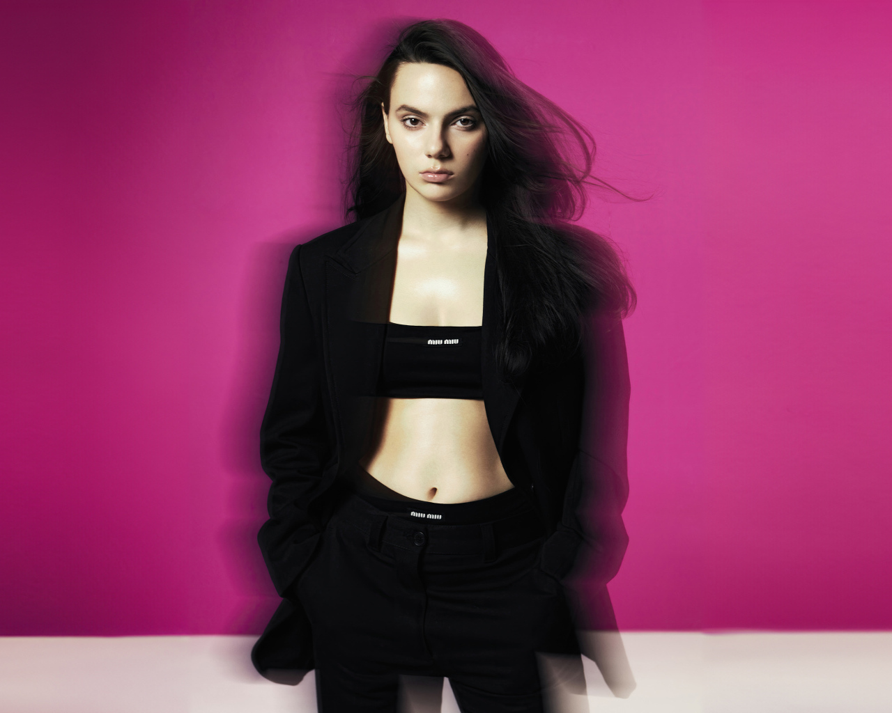 Актриса Дафни Кин стоит у розовой стены