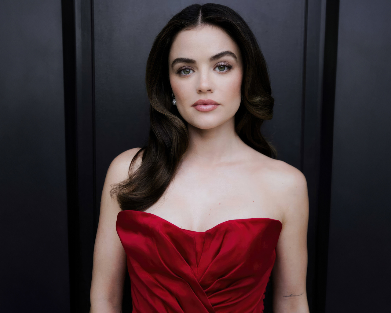 Актриса Люси Хейл в красном платье у серой стены