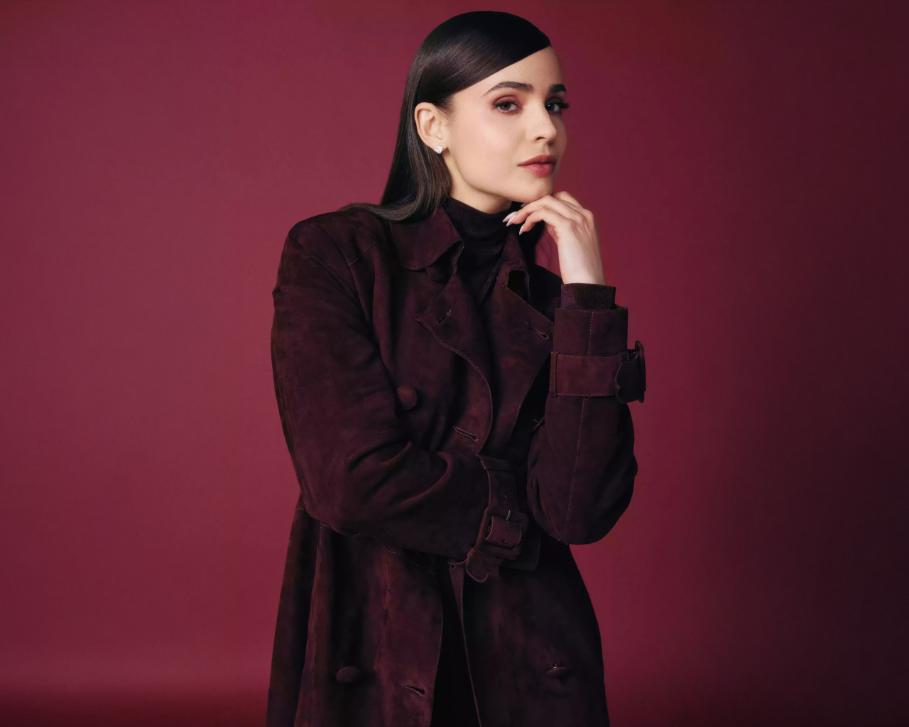 Актриса София Карсон в пальто на бордовом фоне