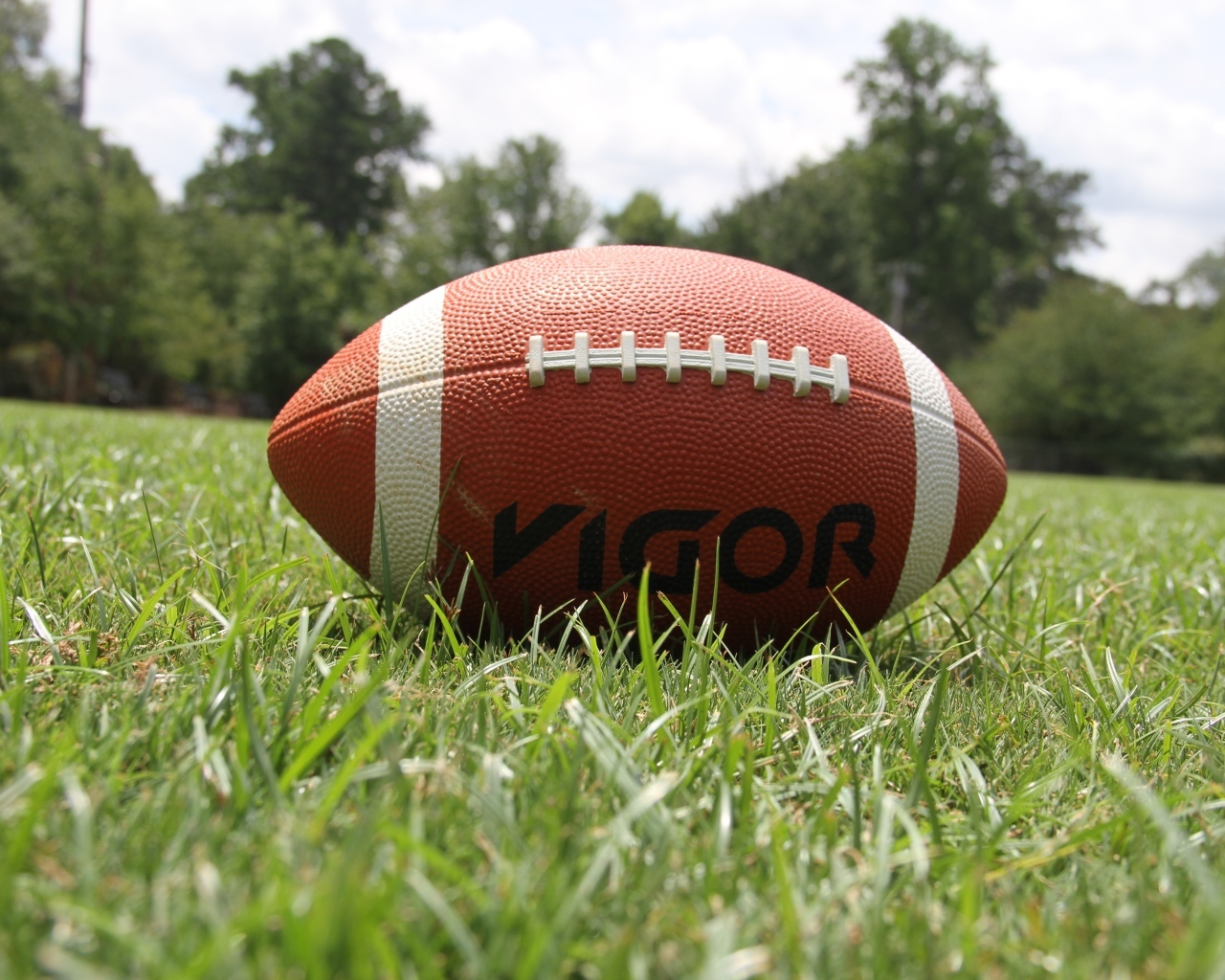 Мяч для американского футбола на зеленой траве 