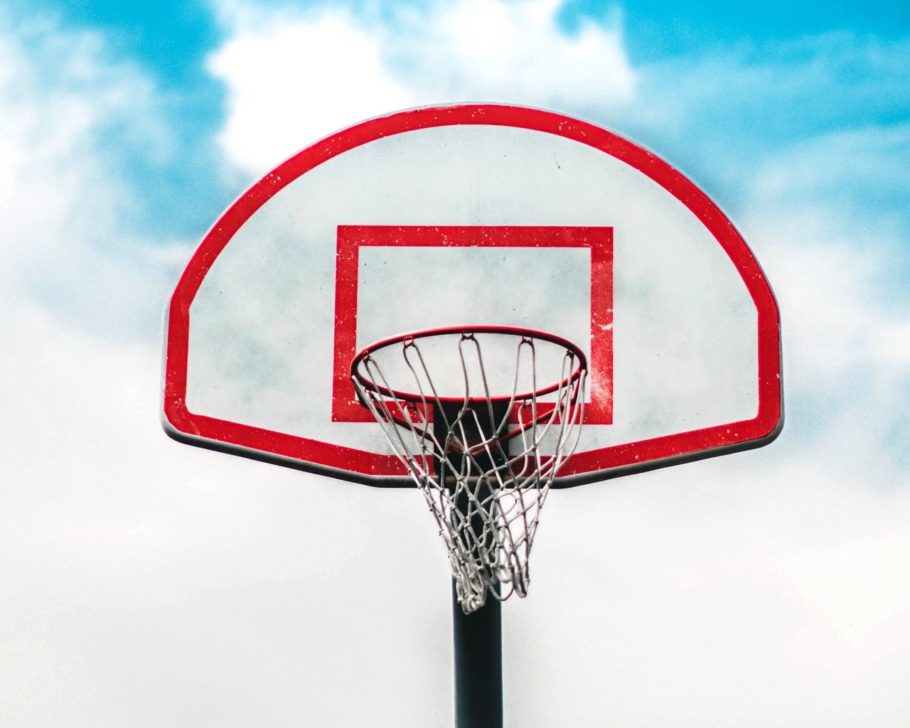 Баскетбольное кольцо на фоне белых облаков