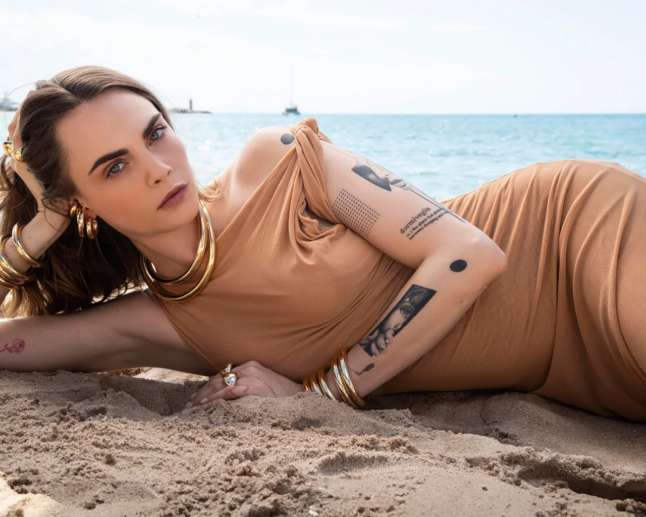 Британская актриса Кара Делевинь лежит на песке на пляже