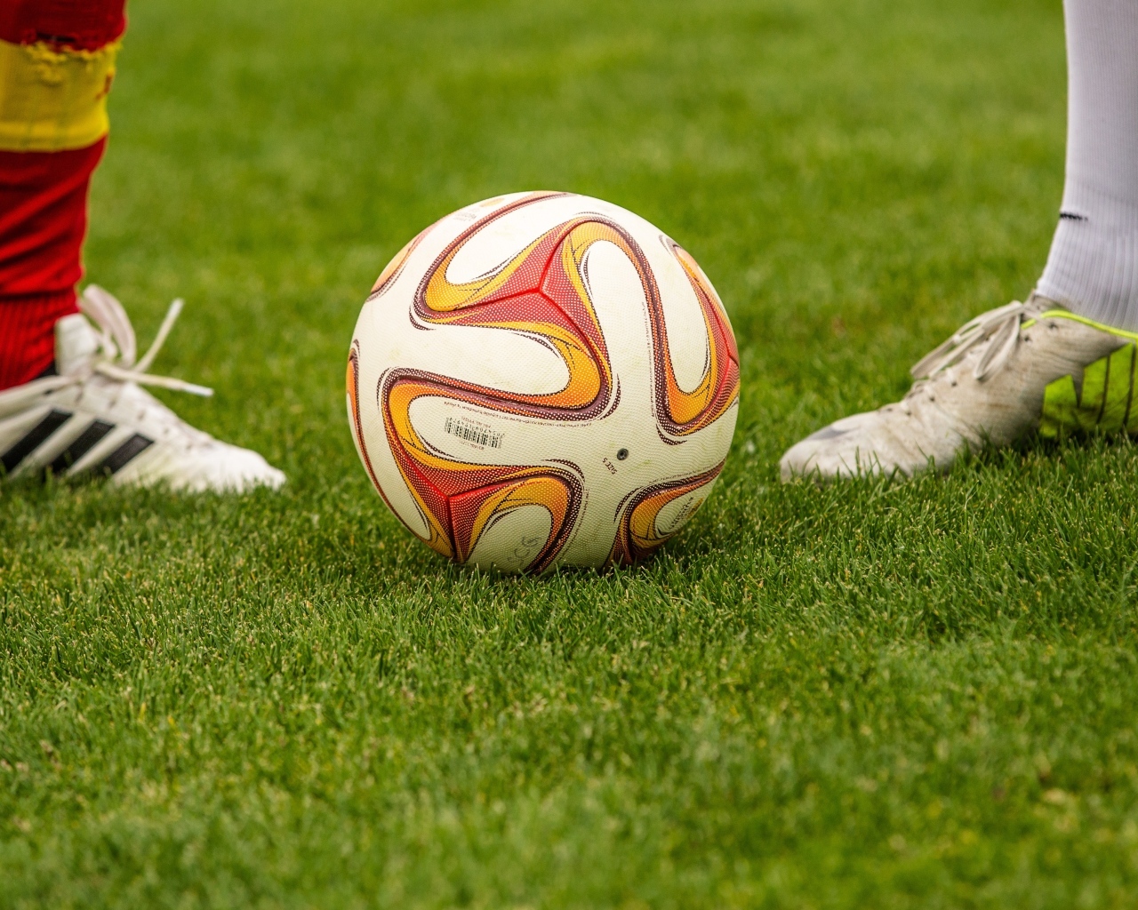 Футболисты с мячом на зеленой траве