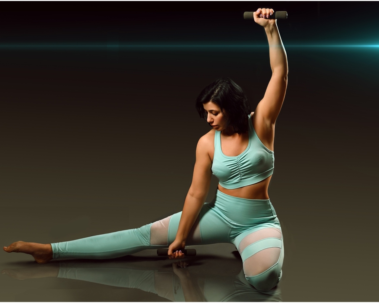 Девушка занимается фитнесом с гантелями