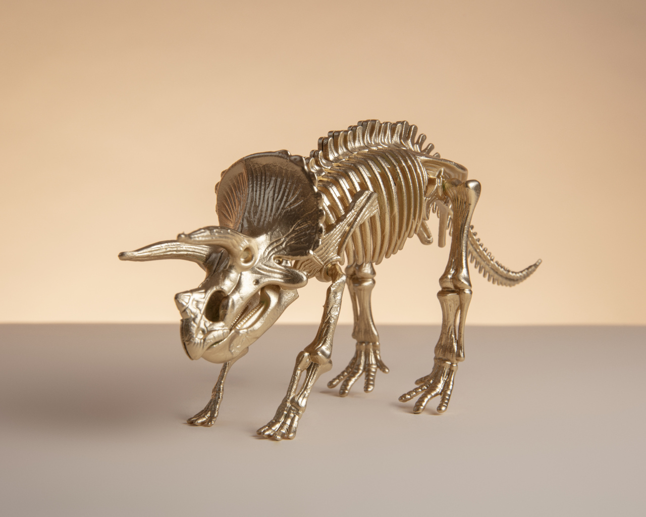 Золотой скелет динозавра на коричневом фоне