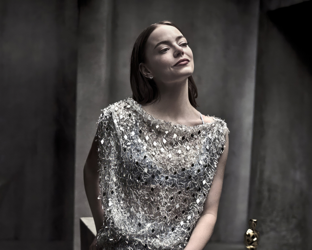 Рыжеволосая актриса Эмма Стоун в блестящем платье в серой комнате