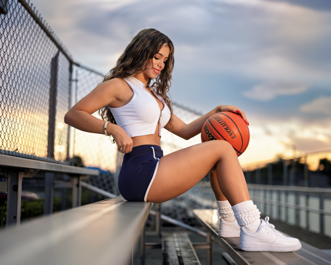 Улыбающаяся спортивная девушка с баскетбольным мячом