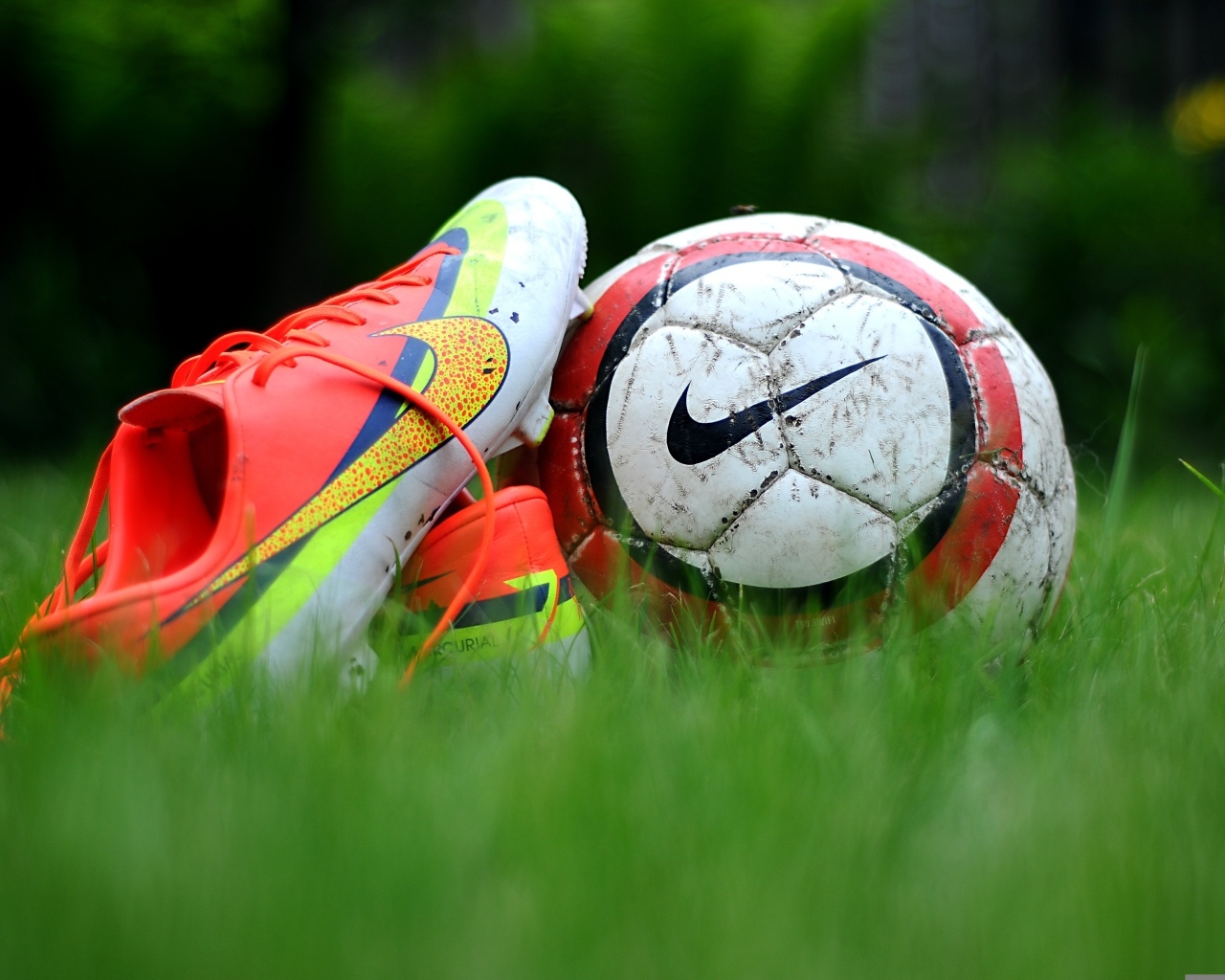 Футбольный мяч и бутсу на зеленой траве