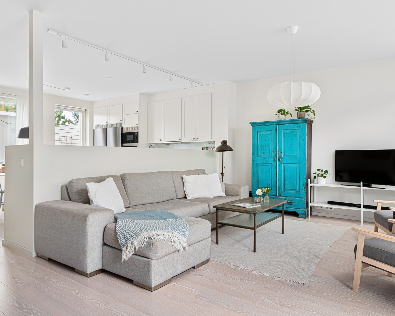 Просторная гостиная комната  с серым диваном