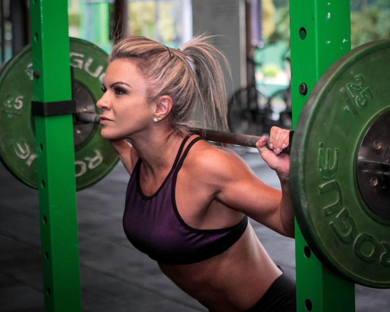 Сильная спортивная девушка поднимает штангу