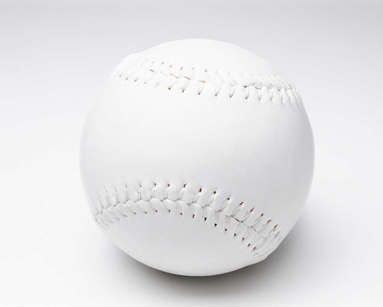 Белый новый бейсбольный мяч на сером фоне