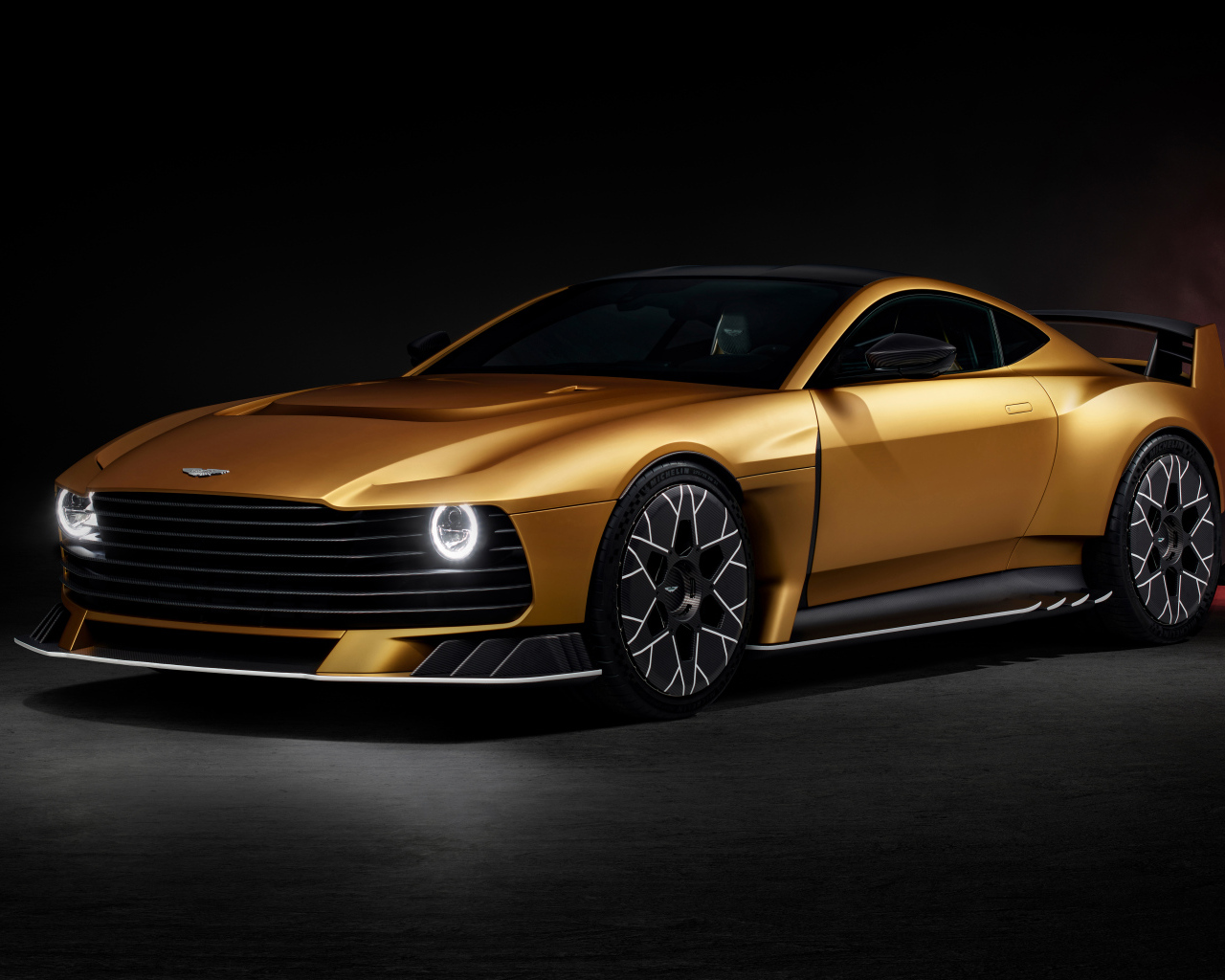 Вид спереди на золотистый автомобиль Aston Martin Valiant 2024 года