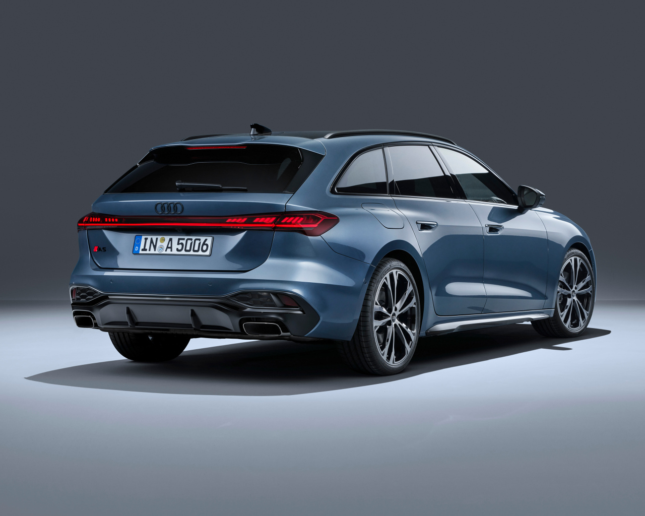 Вид сзади на автомобиль Audi A5 Avant TFSI quattro S line 2024 года на сером фоне