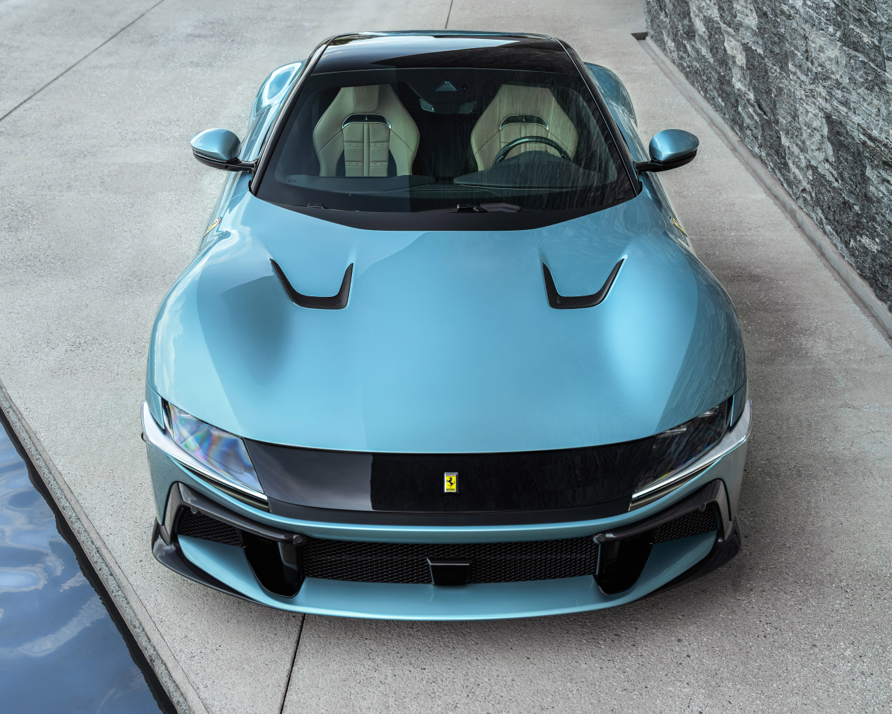 Голубой автомобиль Ferrari 12Cilindri 2024 года вид спереди