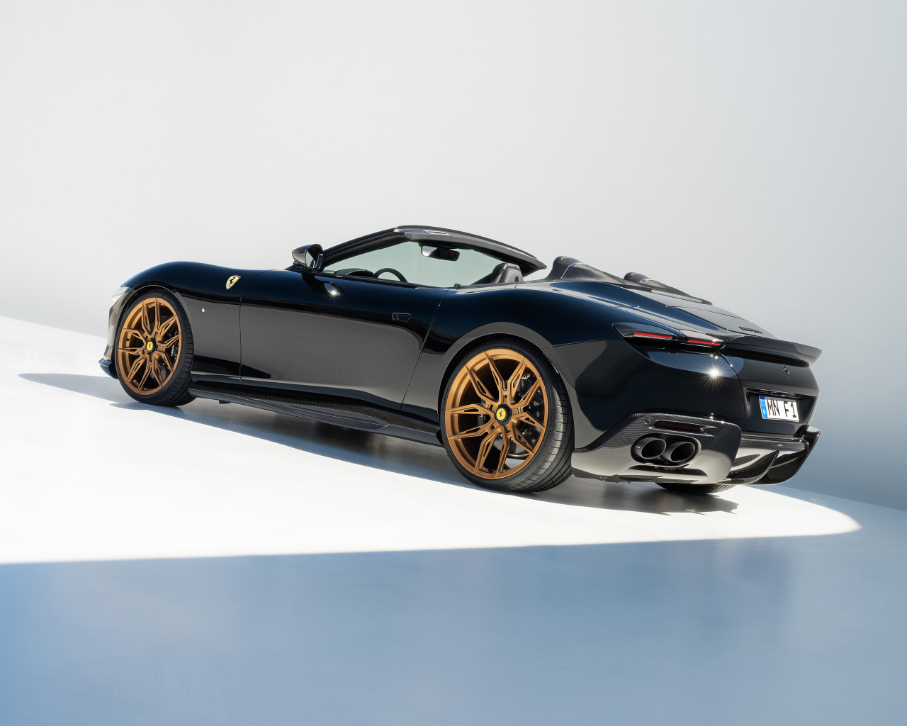 Черный автомобиль Novitec Ferrari Roma Spider 2024 года вид сзади