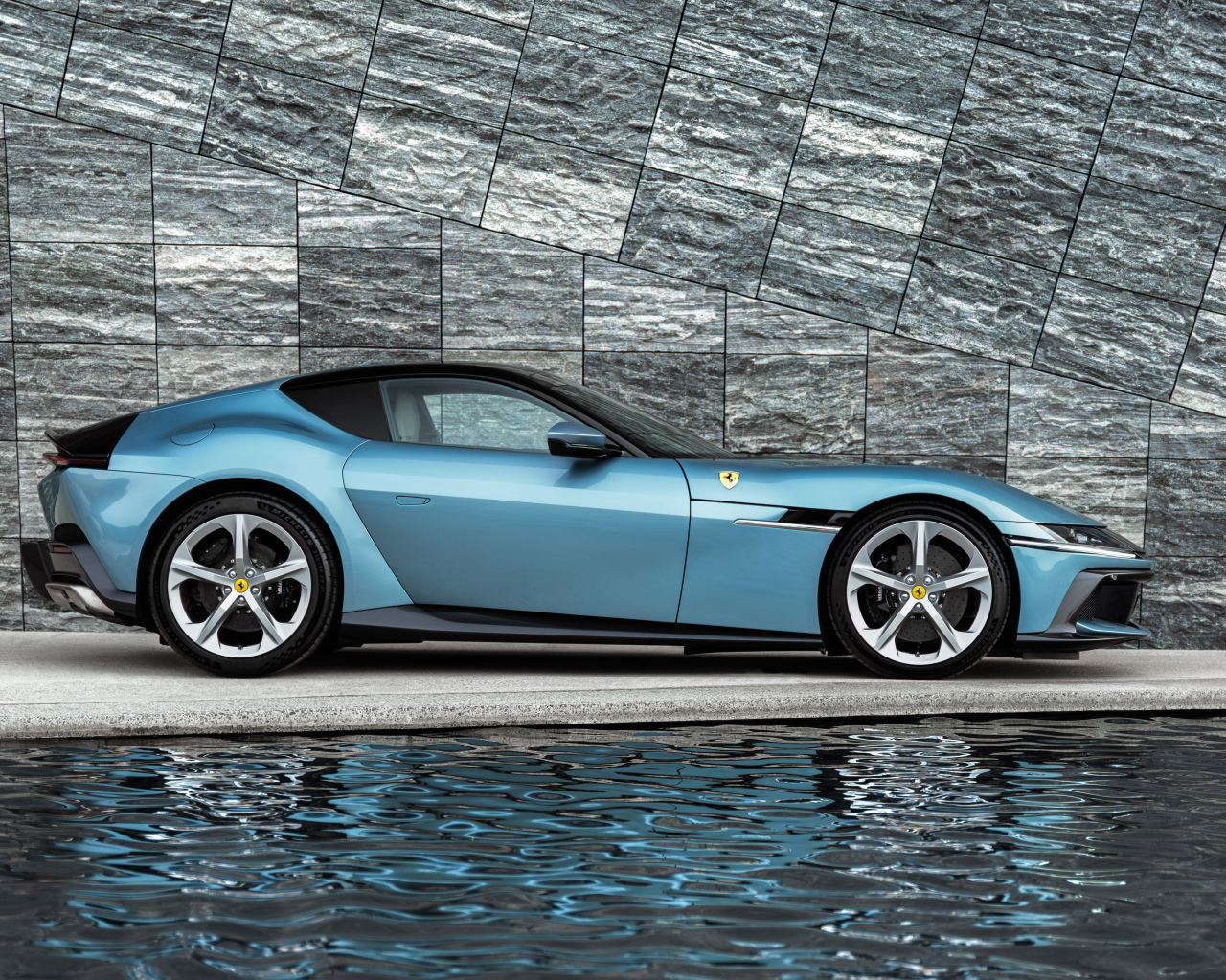 Вид сбоку на голубой автомобиль Ferrari 12Cilindri 2024 года