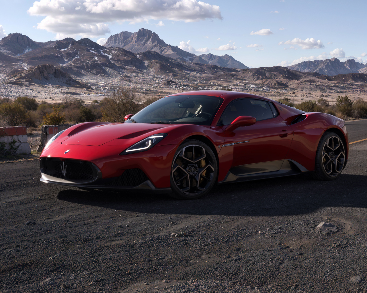 Красный автомобиль Maserati MC20 на фоне гор