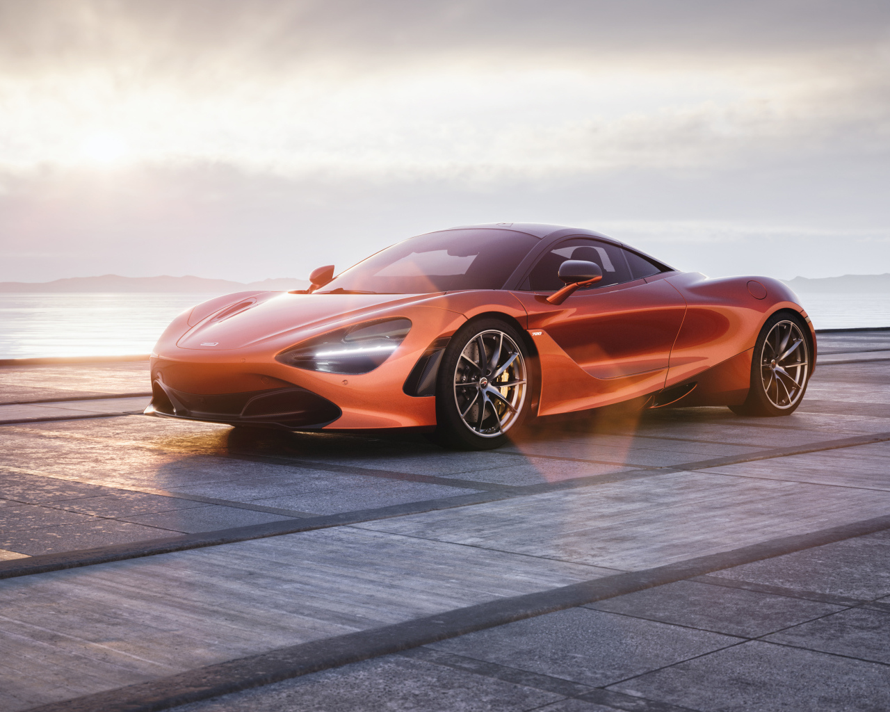 Оранжевый автомобиль McLaren 720S у озера