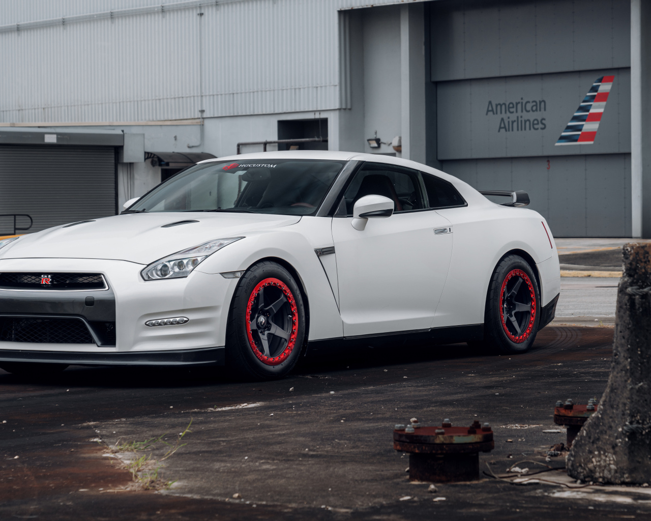 Белый автомобиль Nissan GT-R у гаража