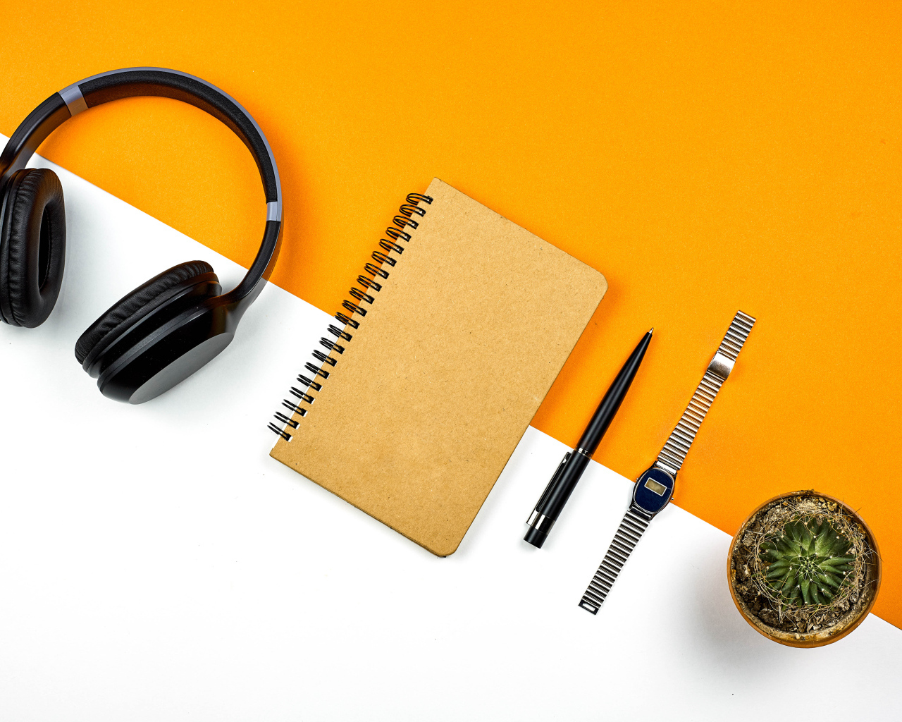 Наушники, блокнот, ручка, часы и цветок на фоне