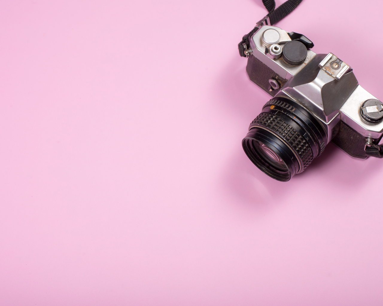 Старый фотоаппарат на розовом фоне