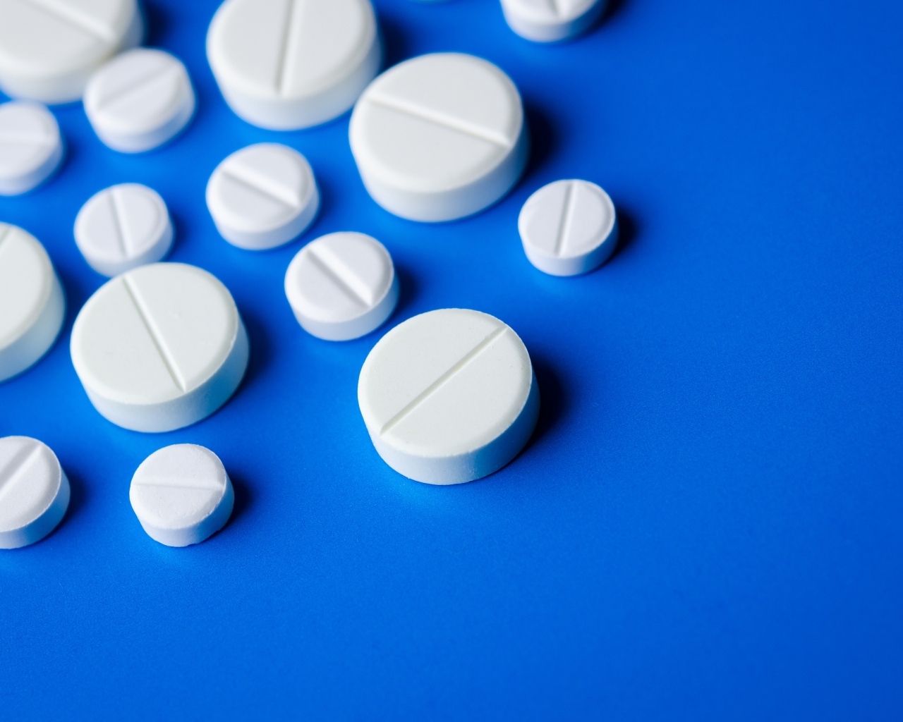 Белые таблетки на синем фоне