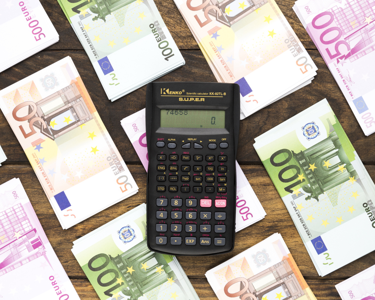 Калькулятор и купюры евро на деревянном столе