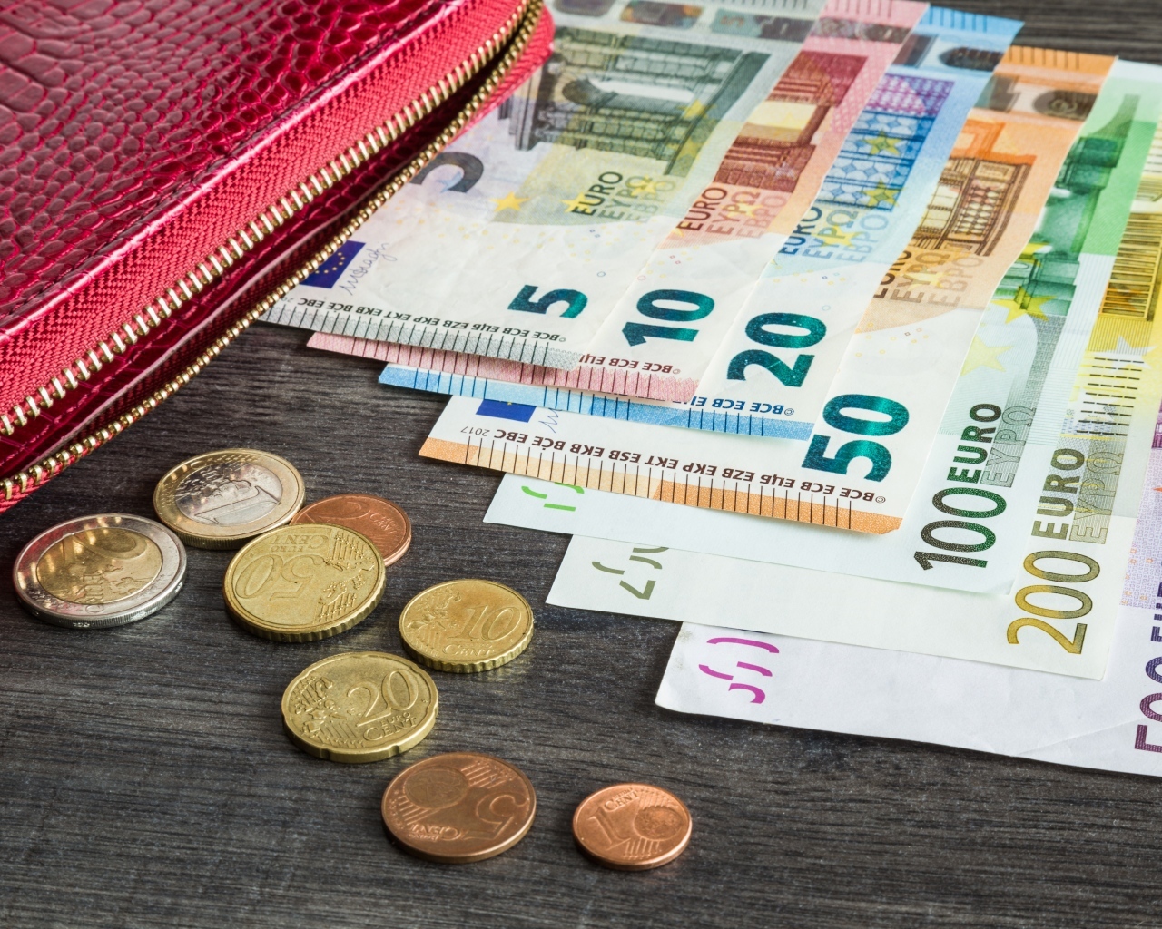 Купюры евро с монетами и кошельком на столе