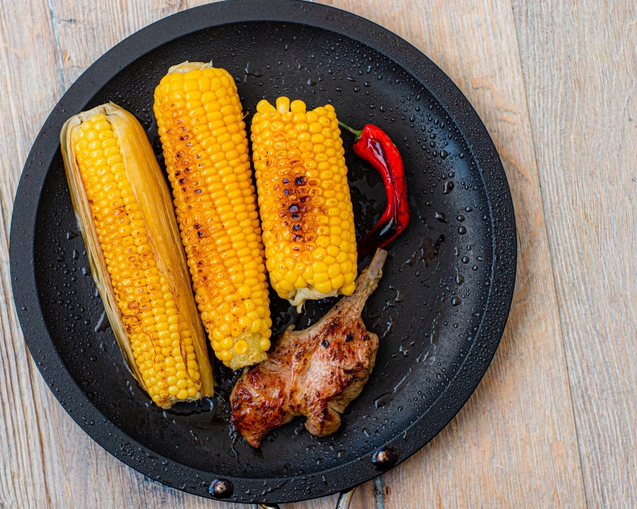 Запеченная кукуруза с ребрышками на тарелке