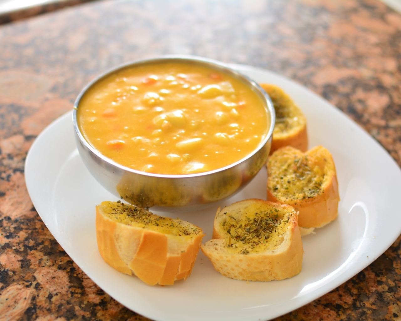 Суп с фасолью на тарелке с гренками