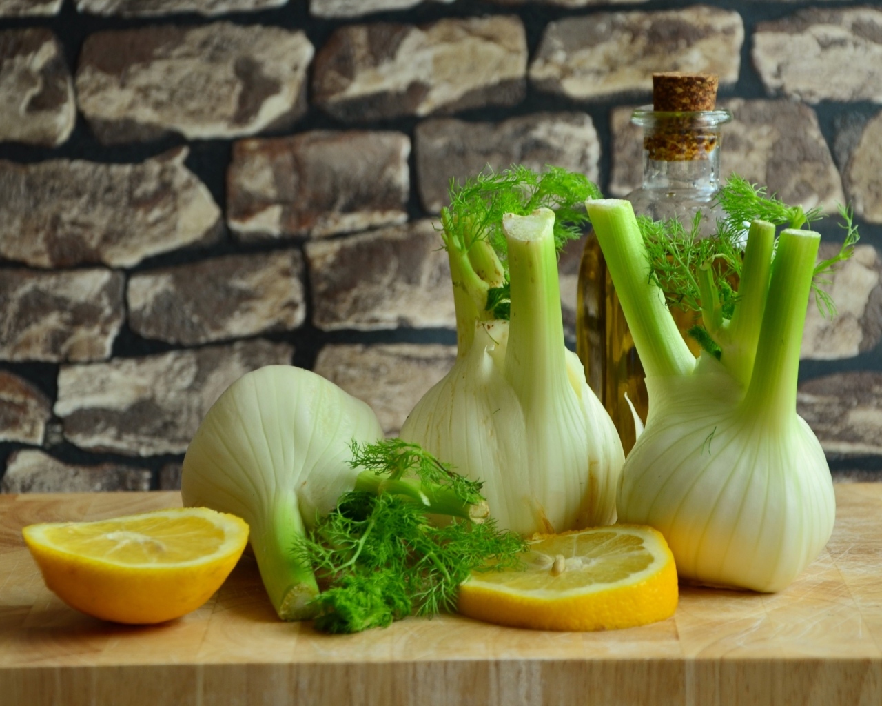 Луковицы фенхеля с кусочками лимона и маслом на столе