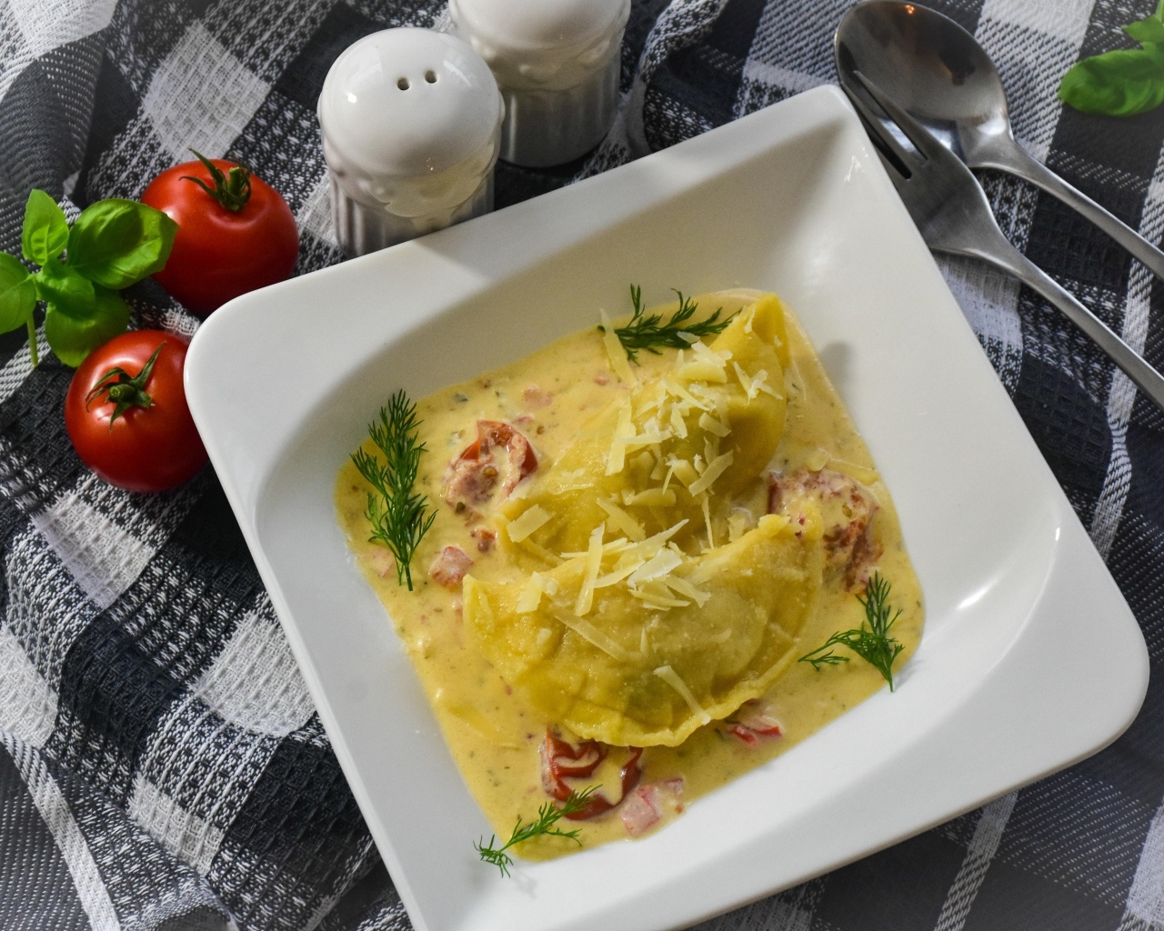 Равиоли с соусе с беконом на тарелке