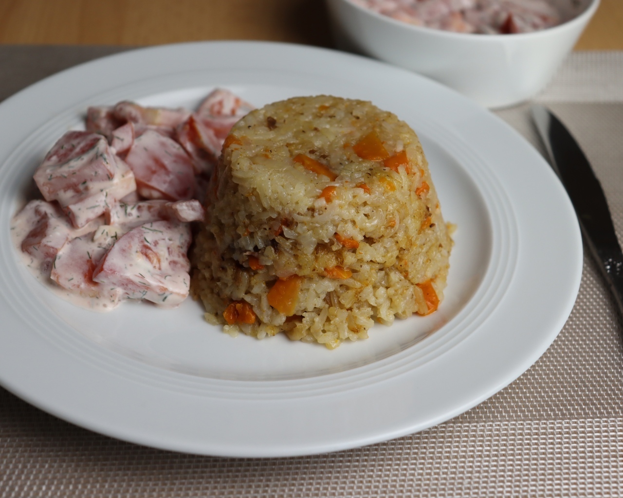 Рис с салатом на большой белой тарелке