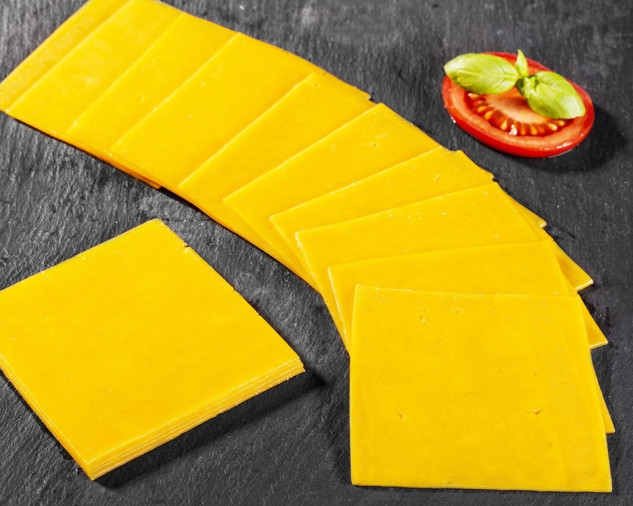 Ломтики сыра с помидором на столе