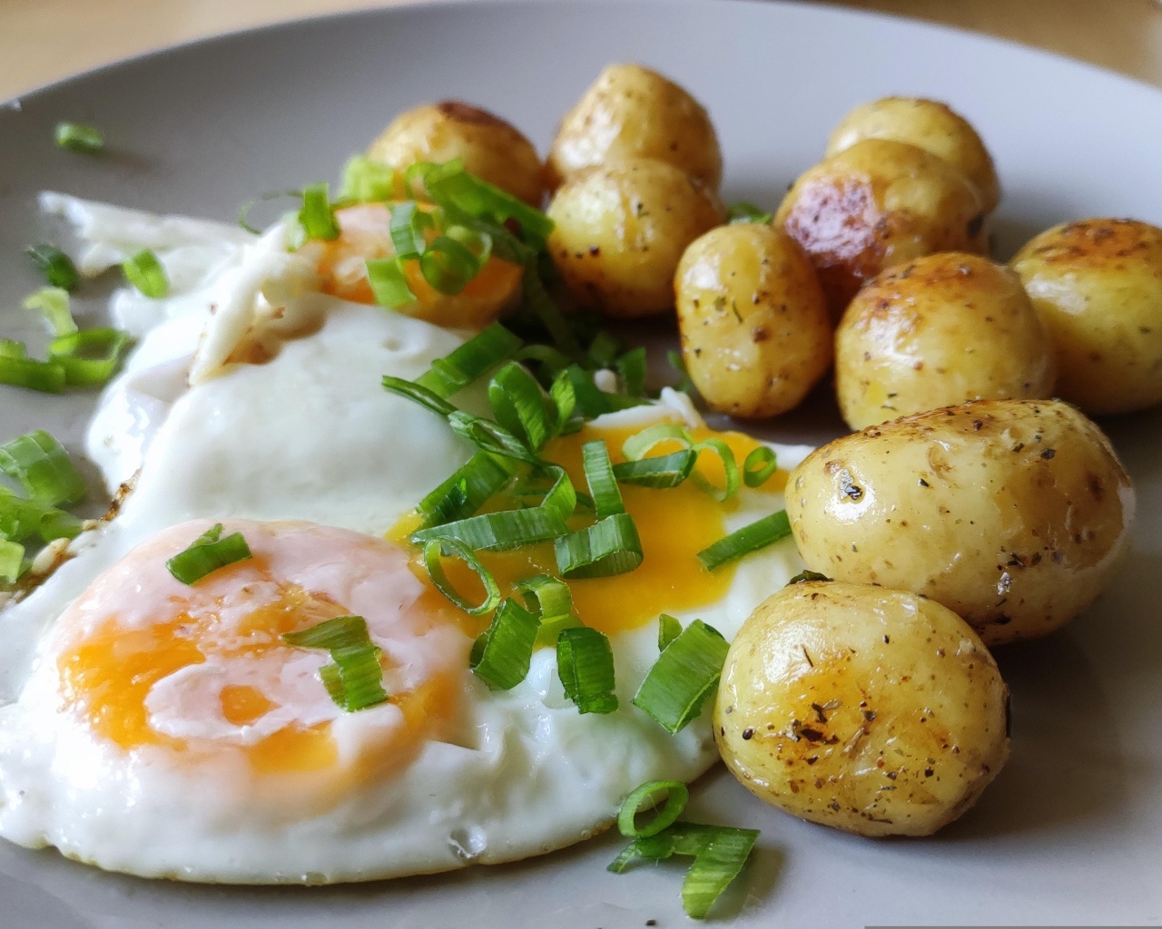 Молодая жареная картошка с яичницей и зеленым луком