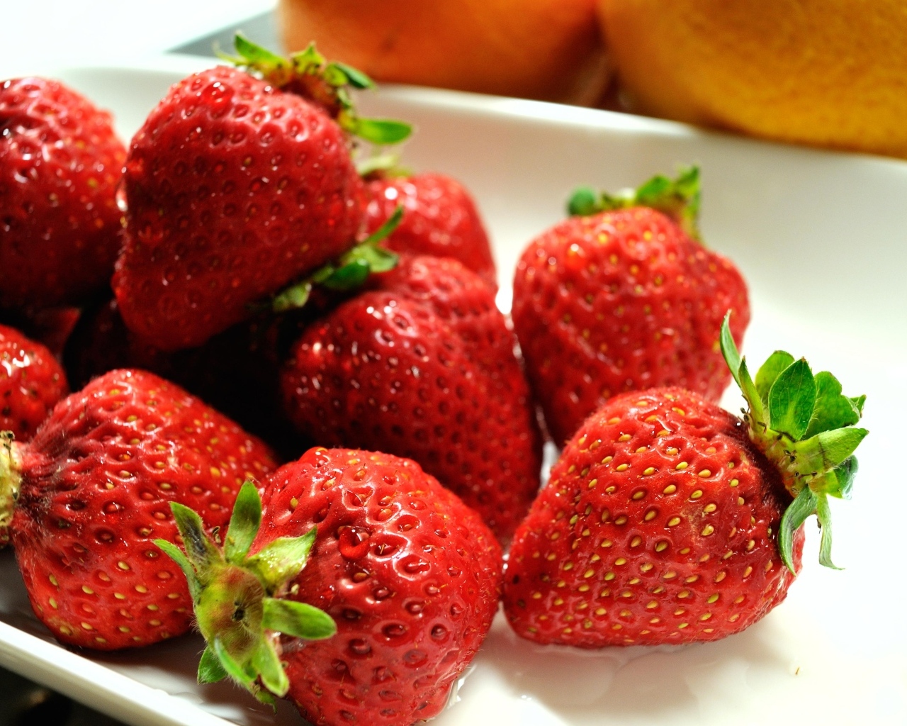 Ароматная красная клубника в белой тарелке