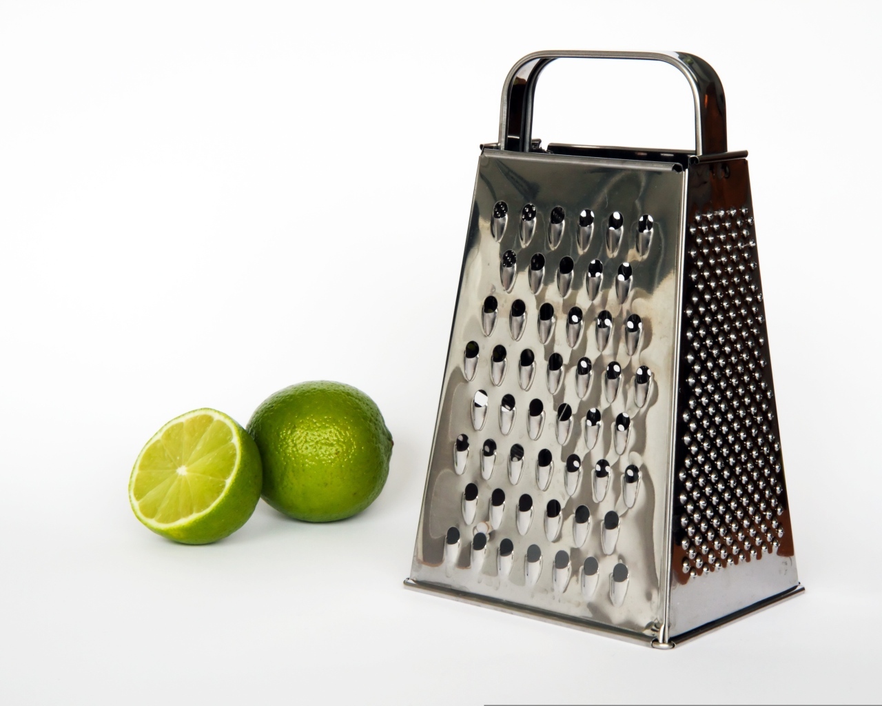 Терка с зеленым лаймом на сером фоне